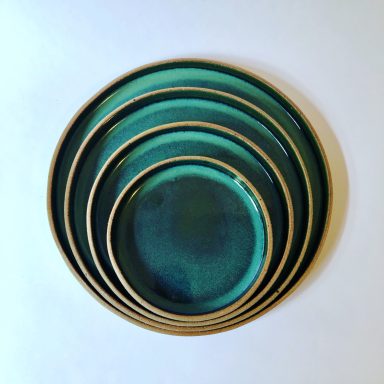 Set of nesting ceramic plates with a green gradient glaze